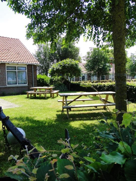 De tuin bij het hotel met picknicktafels in het gras